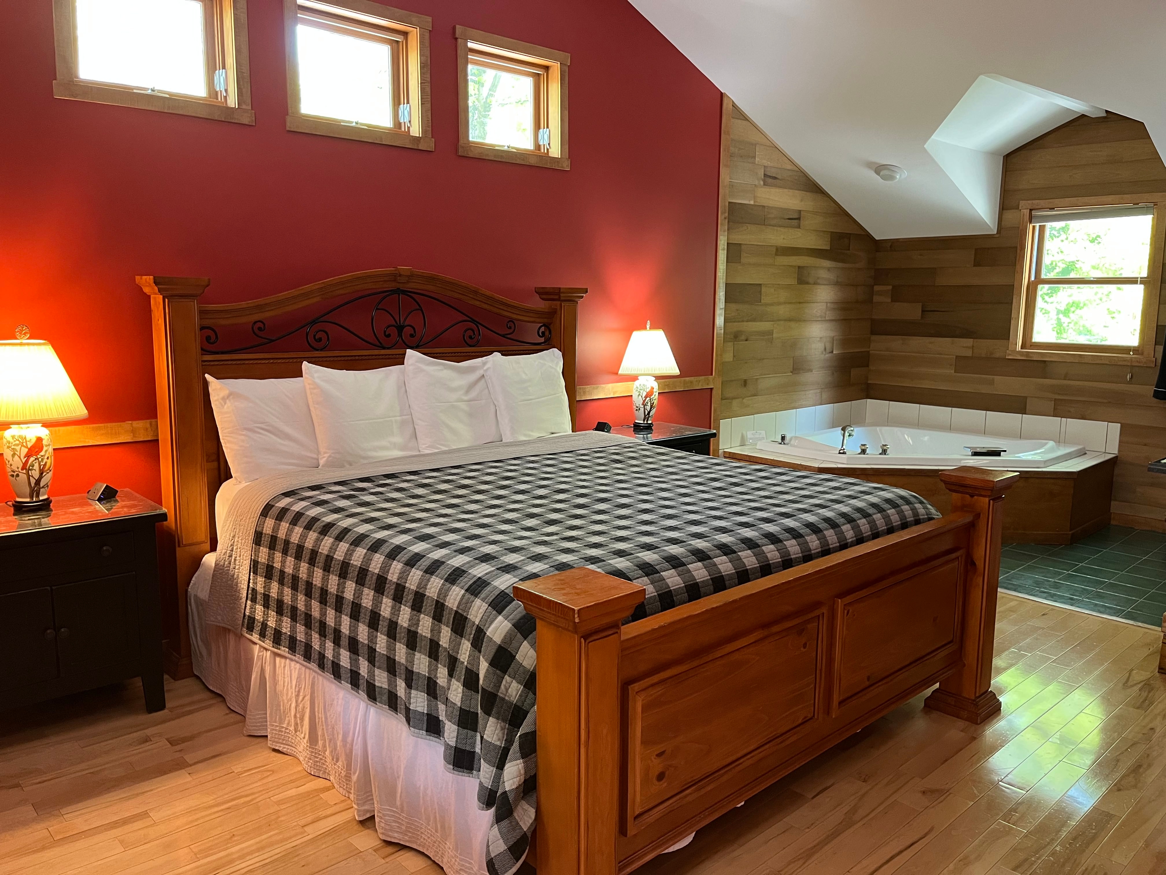 View of King Size bed with double jacuzzi tub and kitchenette in backgroud