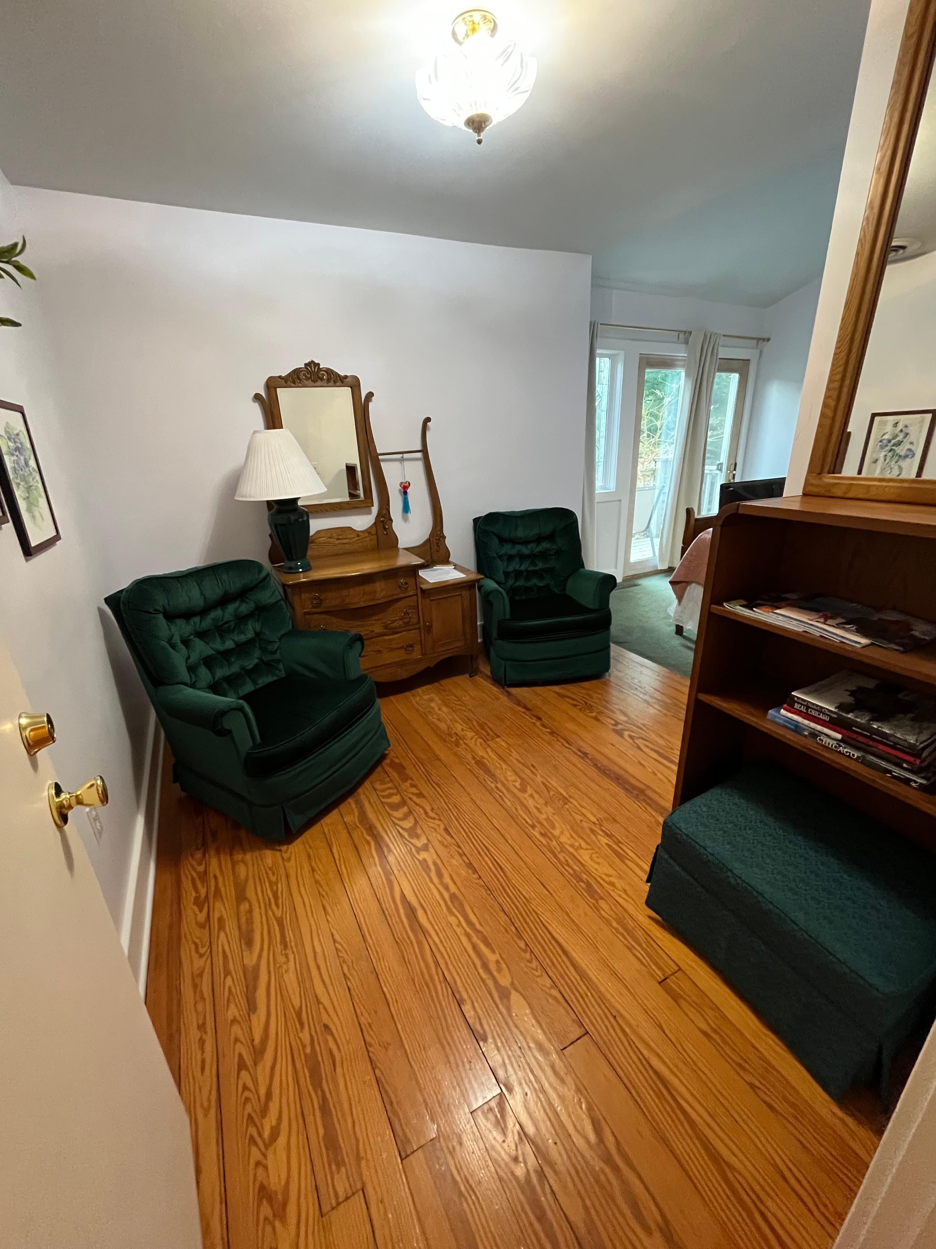 Two green arm chairs with side table and lamp